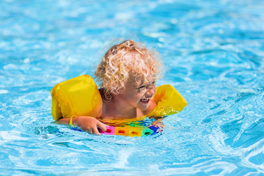 Small kid wearing floaties in the pool